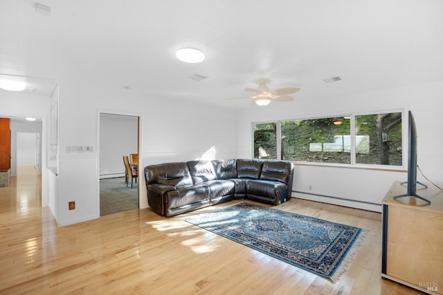 living room with a baseboard radiator, ceiling fan, and light wood-type flooring