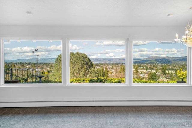 interior space featuring carpet flooring, a chandelier, a baseboard radiator, and a mountain view