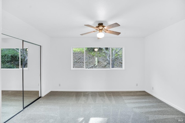 unfurnished bedroom featuring light carpet, a closet, and ceiling fan