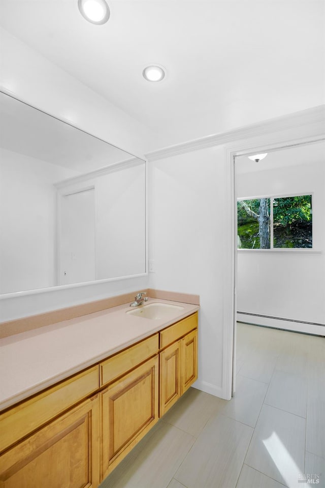 bathroom with a baseboard heating unit, tile flooring, and vanity