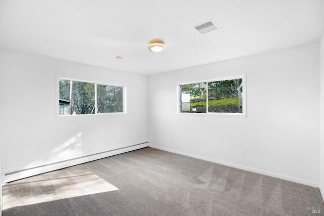 carpeted spare room featuring a baseboard radiator and plenty of natural light