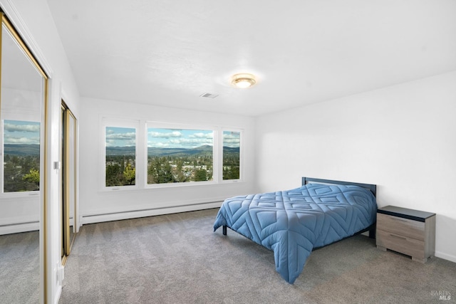 carpeted bedroom featuring a baseboard heating unit