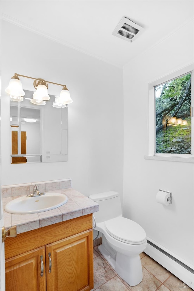 bathroom with a baseboard radiator, toilet, tile floors, and vanity with extensive cabinet space