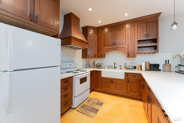 kitchen with tasteful backsplash, white appliances, hanging light fixtures, custom range hood, and sink