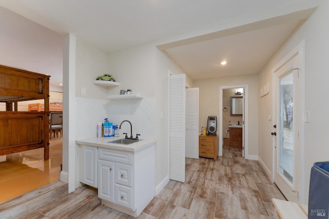 hallway featuring sink and light hardwood / wood-style flooring