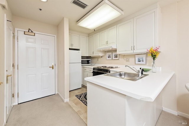 kitchen with sink, kitchen peninsula, appliances with stainless steel finishes, and white cabinetry