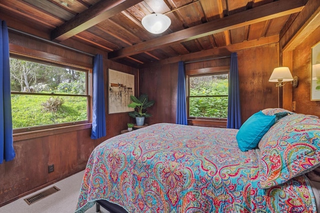 carpeted bedroom with wood walls, multiple windows, wood ceiling, and beam ceiling