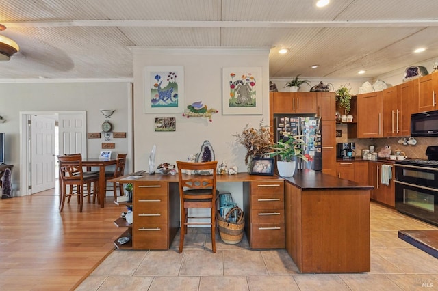 kitchen with light hardwood / wood-style floors, black appliances, a kitchen bar, crown molding, and decorative backsplash