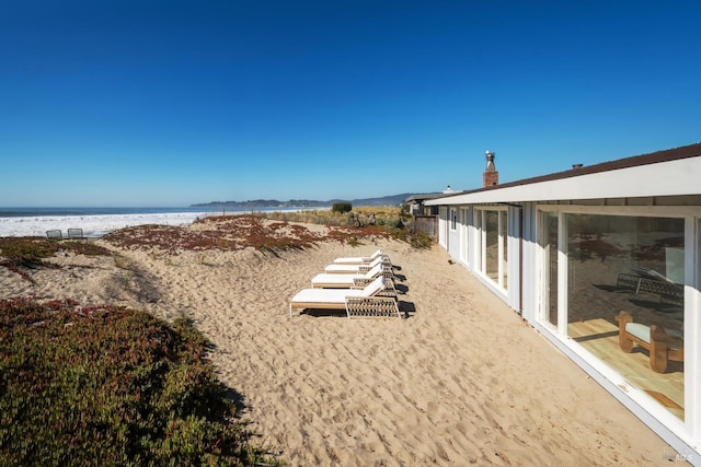 view of yard featuring a view of the beach and a water view