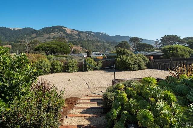 exterior space featuring volleyball court, fence, and a mountain view