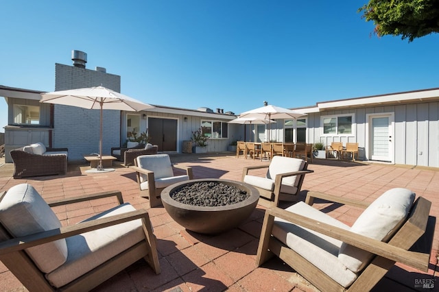 view of patio / terrace with outdoor dining space and an outdoor living space with a fire pit