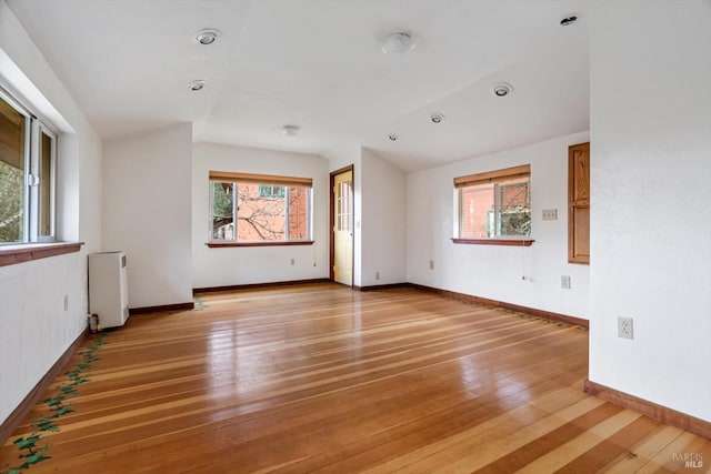 unfurnished room featuring radiator and light hardwood / wood-style flooring