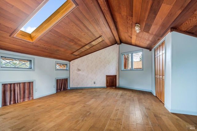 additional living space featuring vaulted ceiling with skylight, light wood-type flooring, and wood ceiling