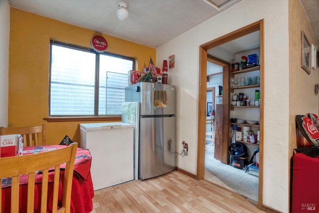 kitchen featuring light wood-type flooring, stainless steel refrigerator, and fridge