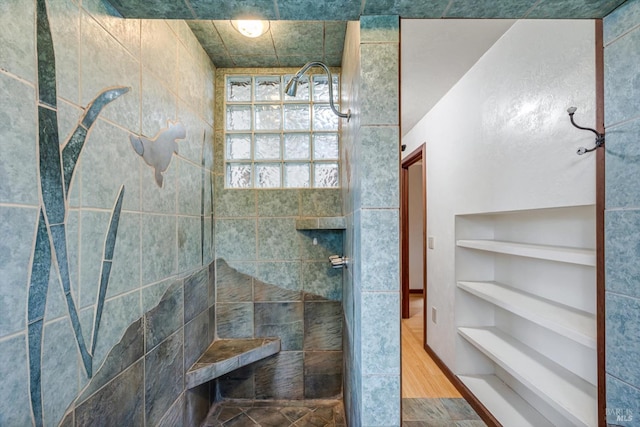 bathroom featuring a tile shower and hardwood / wood-style flooring