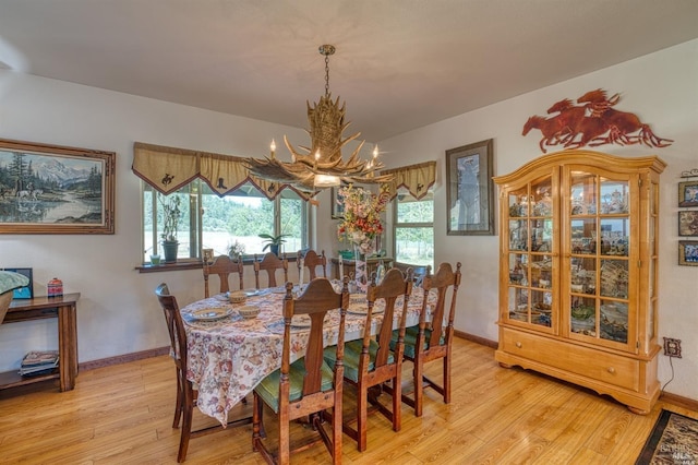 dining room with light hardwood / wood-style flooring and a chandelier