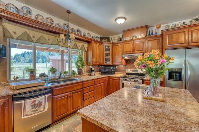 kitchen with pendant lighting, a chandelier, tasteful backsplash, sink, and stainless steel appliances