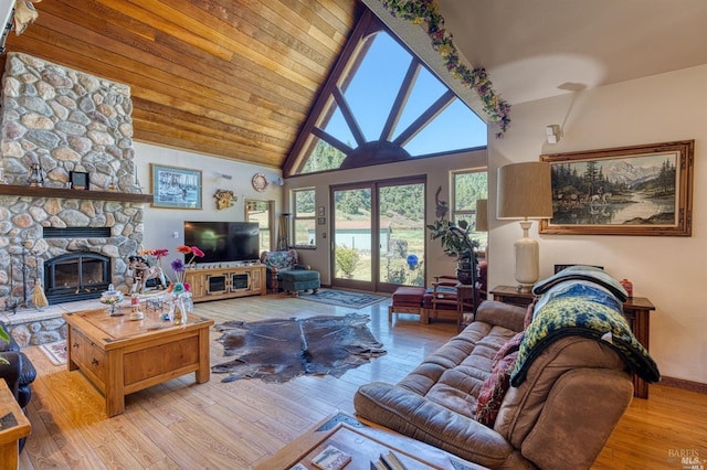 living room with high vaulted ceiling, light hardwood / wood-style floors, and a fireplace