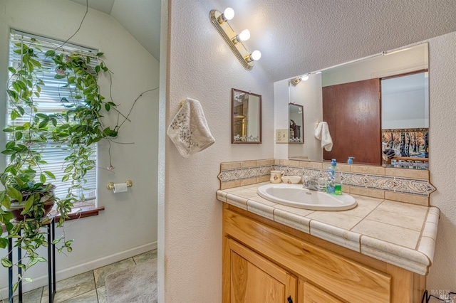 bathroom with vanity and vaulted ceiling