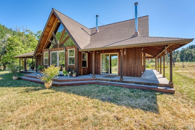 rear view of property featuring a wooden deck and a lawn