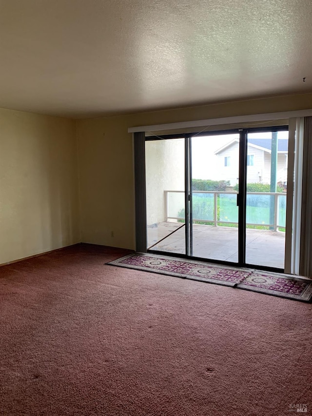 unfurnished room featuring a textured ceiling and carpet floors