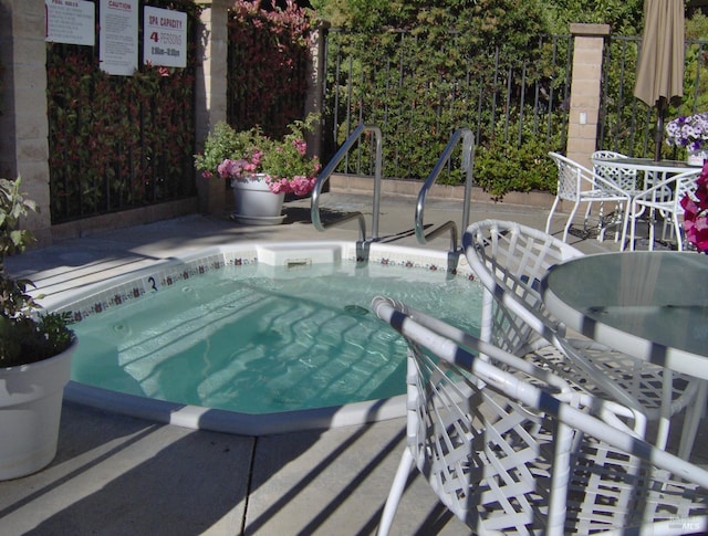 view of swimming pool featuring a hot tub