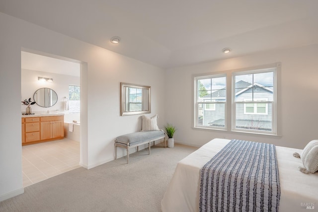 bedroom featuring light carpet and connected bathroom