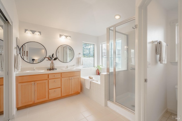 bathroom with dual vanity, shower with separate bathtub, and tile floors