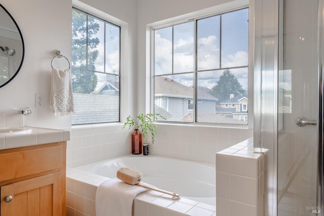 bathroom featuring shower with separate bathtub and vanity with extensive cabinet space