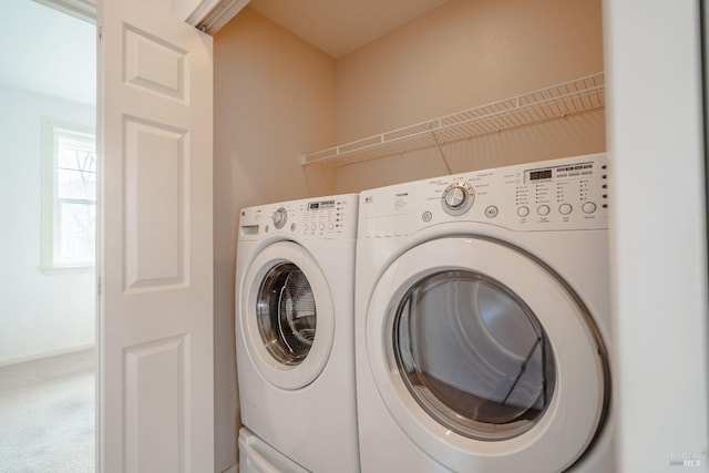 clothes washing area featuring washer and dryer and carpet flooring