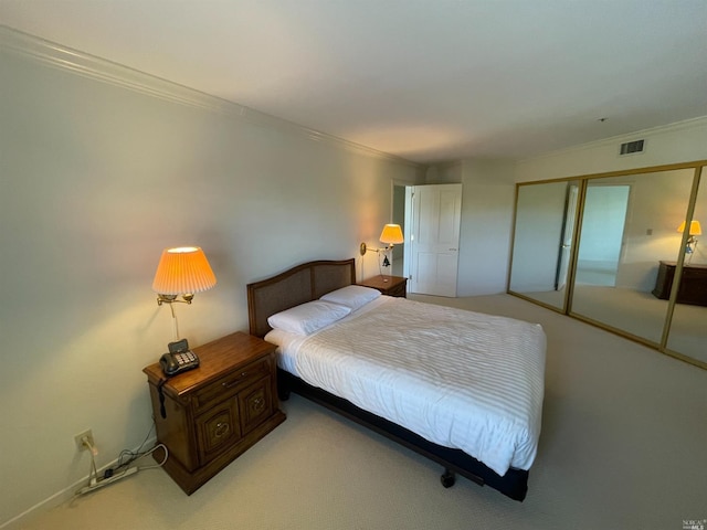 carpeted bedroom with ornamental molding and a closet