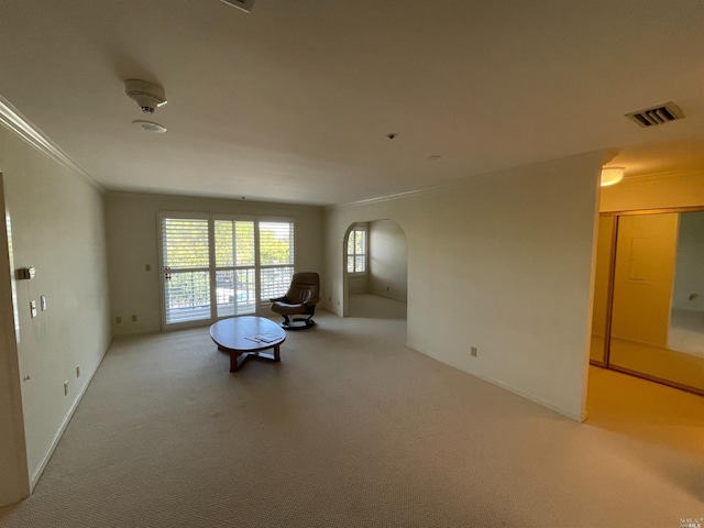 interior space with crown molding and light colored carpet