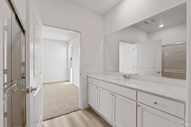 bathroom with vanity, wood-type flooring, and walk in shower