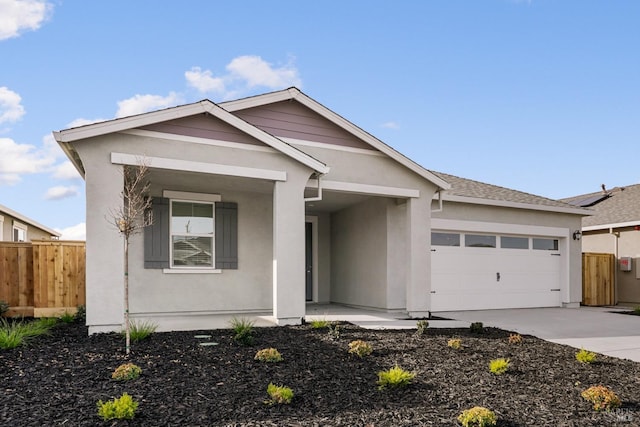 view of front of home featuring stucco siding, an attached garage, driveway, and fence