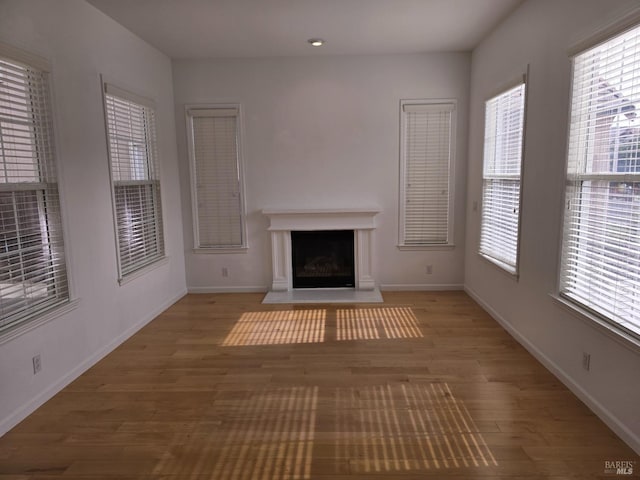 unfurnished living room featuring dark wood-type flooring and a healthy amount of sunlight