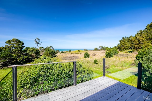 wooden terrace with a lawn and a water view
