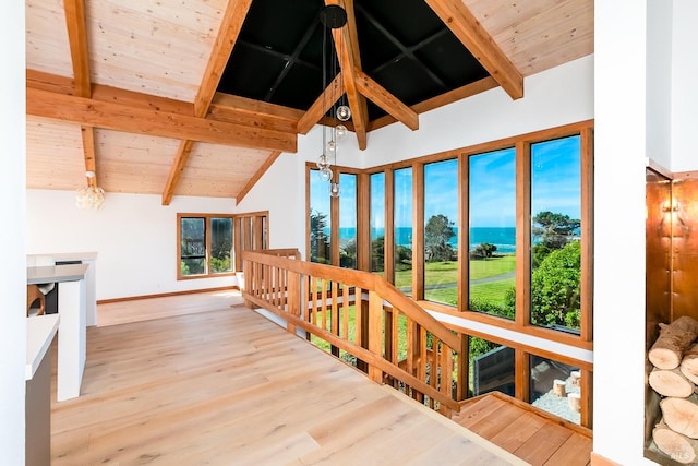 interior space featuring high vaulted ceiling, wooden ceiling, wood finished floors, baseboards, and beam ceiling