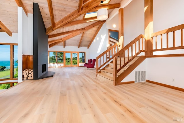 unfurnished living room featuring visible vents, beamed ceiling, high vaulted ceiling, wood ceiling, and wood finished floors