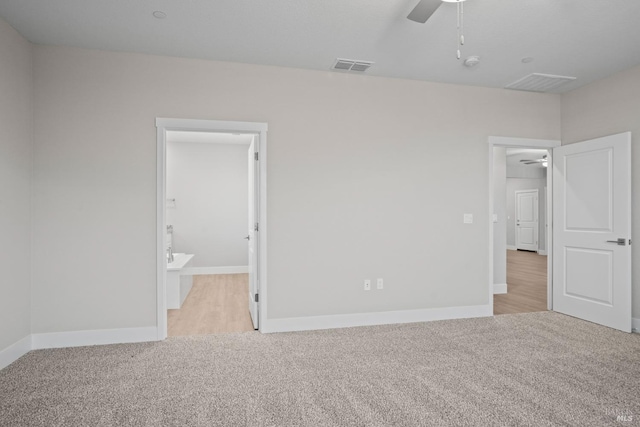 unfurnished bedroom with ceiling fan, connected bathroom, and light carpet