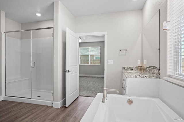 bathroom with hardwood / wood-style floors, vanity, and independent shower and bath