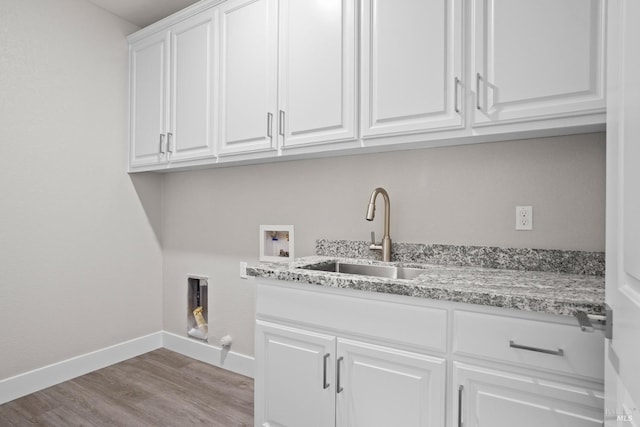 laundry area with a sink, wood finished floors, cabinet space, baseboards, and hookup for a washing machine