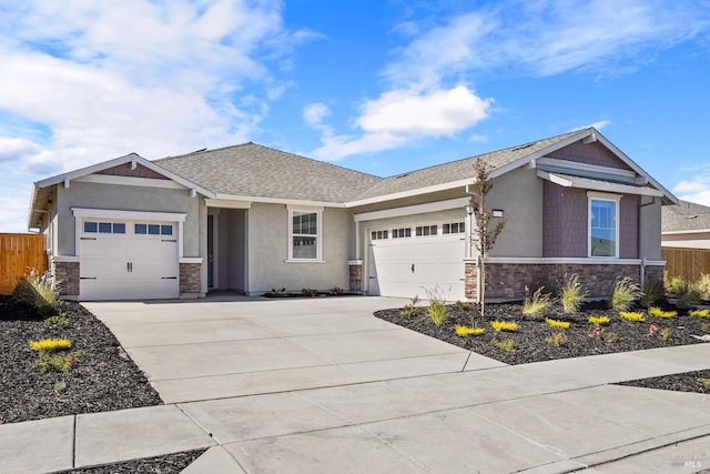 view of front facade featuring an attached garage, concrete driveway, and fence