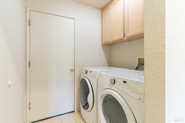 clothes washing area featuring cabinets and separate washer and dryer