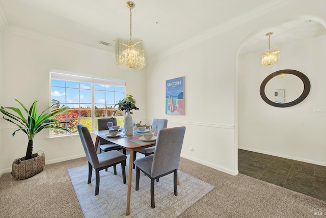 carpeted dining room featuring an inviting chandelier, ornamental molding, baseboards, and visible vents