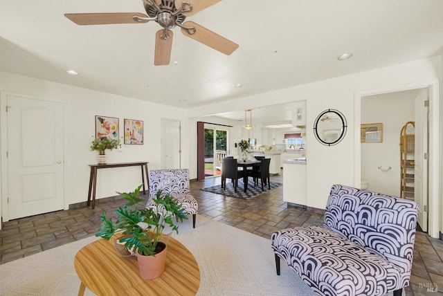 living room with ceiling fan, recessed lighting, and stone tile floors