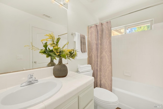 full bathroom with vanity, shower / bath combo, and toilet