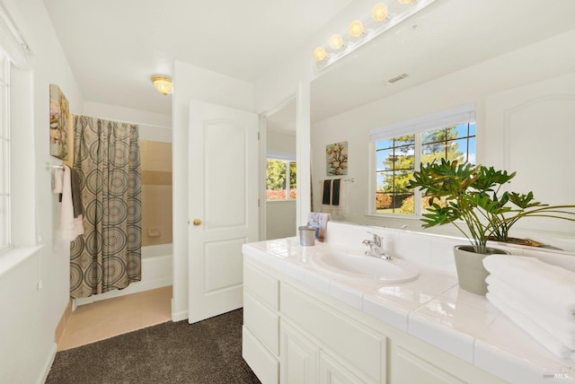 bathroom featuring visible vents, shower / bathtub combination with curtain, and vanity