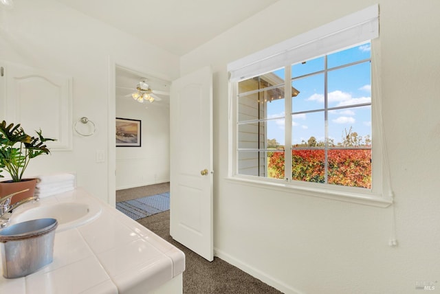 bathroom featuring baseboards, a ceiling fan, a healthy amount of sunlight, and vanity