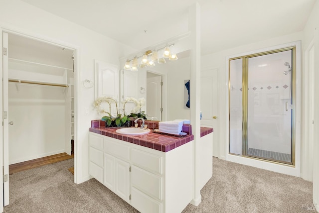 full bath with vanity, carpet, a shower with door, and a walk in closet