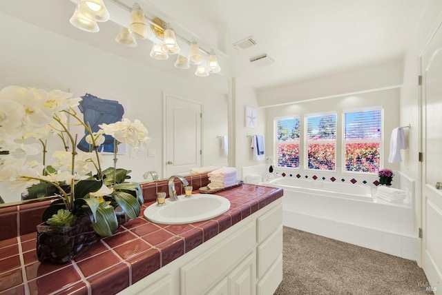 bathroom featuring vanity, a garden tub, and visible vents